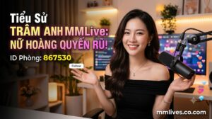 Banner hồ sơ idol Trâm Anh MMLive, giới thiệu 'Nữ hoàng quyến rũ!' với ID phòng 867530. Hình ảnh một nữ streamer trẻ mỉm cười trước thiết bị livestream, với các biểu tượng trái tim và kim cương bay lên. Bao gồm domain nanogate.io.